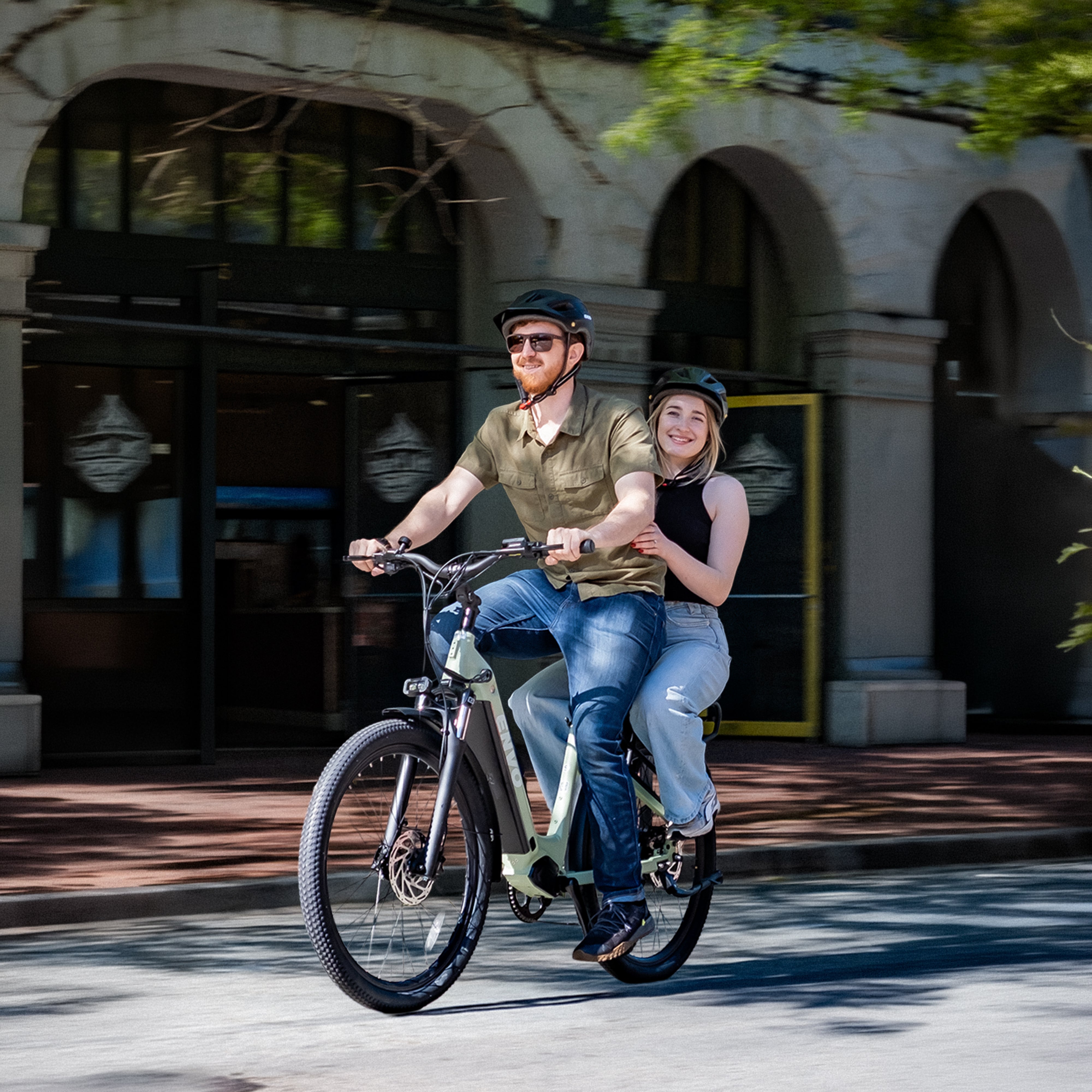Couple riding ENVO electric bikes along a Vancouver waterfront cycling path