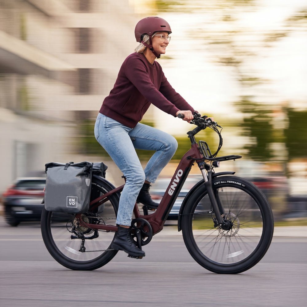Woman commuting on ENVO electric bike with panniers through city streets
